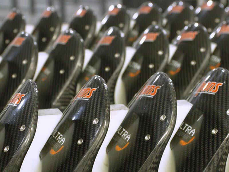 Image shows three rows of completed HANS devices, placed in white slots. It is the head section of the device and includes the customer's branded graphics. 